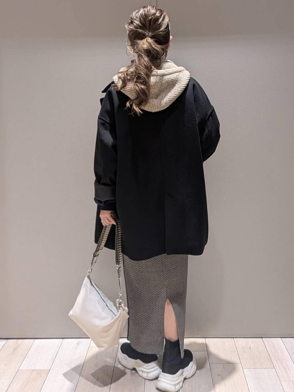 ブラック系のスカート、ブラック系のその他アウター、ブラック系のブーツを着用したレディースの秋コーディネートの3枚目の写真