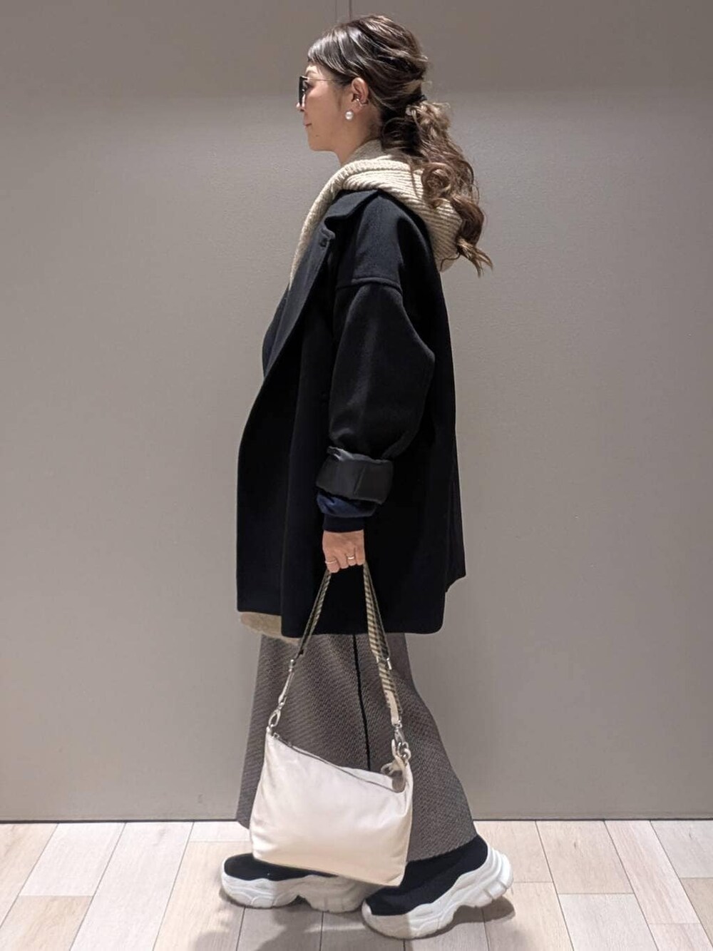 ブラック系のスカート、ブラック系のその他アウター、ブラック系のブーツを着用したレディースの秋コーディネートの2枚目の写真