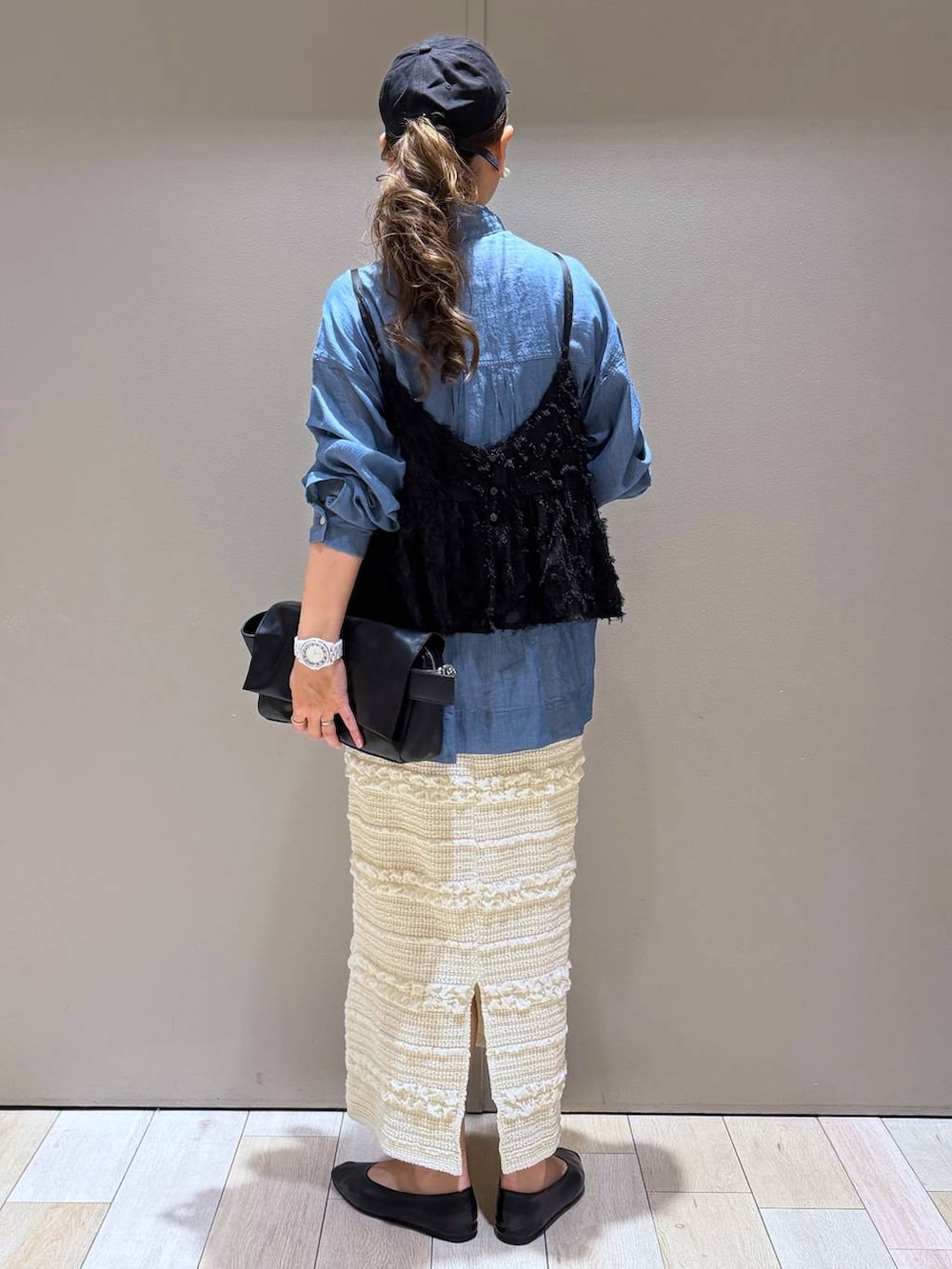 ブラック系のショルダーバッグ、ブラック系のパンプス、ブルー系のシャツ/ブラウスを着用したレディースの春コーディネートの3枚目の写真