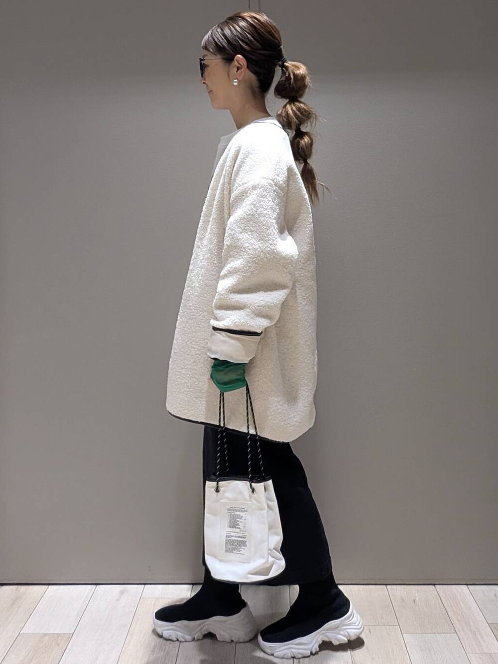 ホワイト系のその他アウター、ホワイト系のTシャツ/カットソー、ブラック系のTシャツ/カットソーを着用したレディースの冬コーディネートの2枚目の写真
