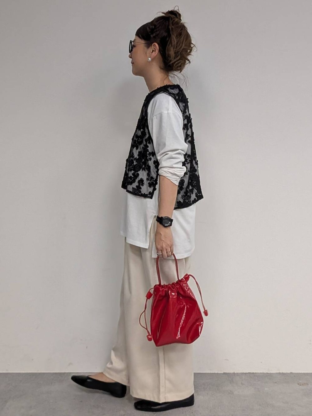 ホワイト系のTシャツ/カットソー、ホワイト系のスラックス、ブラック系のベストを着用したレディースの冬コーディネートの2枚目の写真