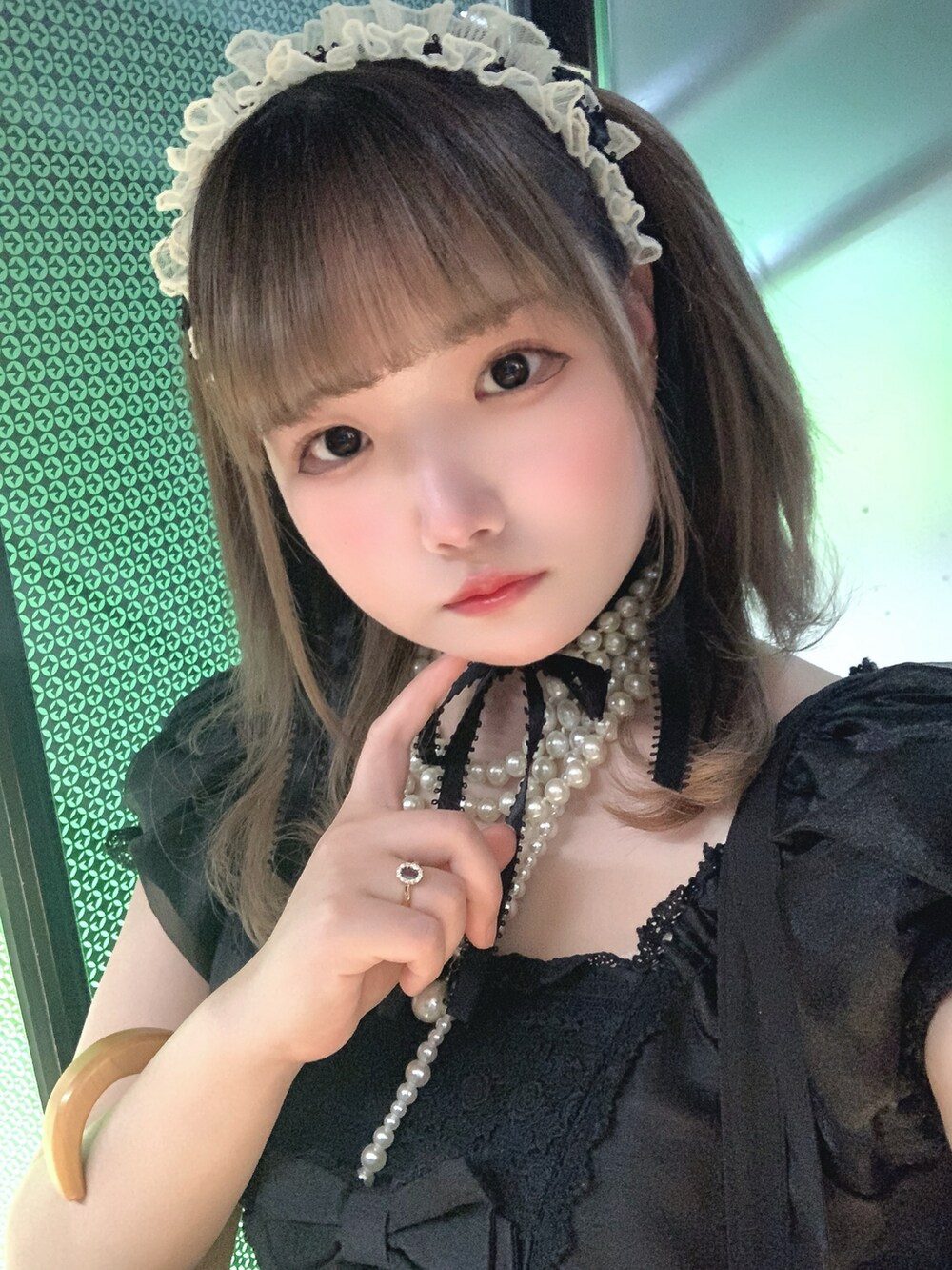 ブラック系のワンピース、ベージュ系のショルダーバッグ、ブラック系のパンプスを着用したレディースの春コーディネートの2枚目の写真