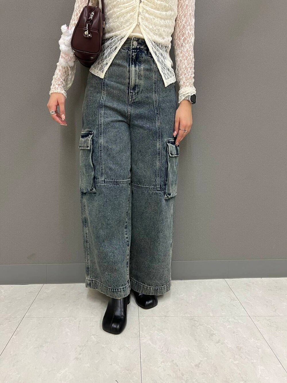 ホワイト系のキャミソール、ブラック系のサンダル、レッド系のボストンバッグを着用したレディースの夏コーディネートの3枚目の写真