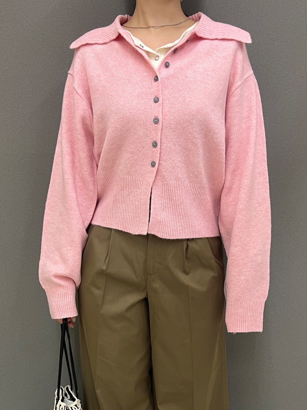 ピンク系のニット/セーター、ホワイト系のTシャツ/カットソー、ベージュ系のその他パンツを着用したレディースの秋コーディネートの2枚目の写真