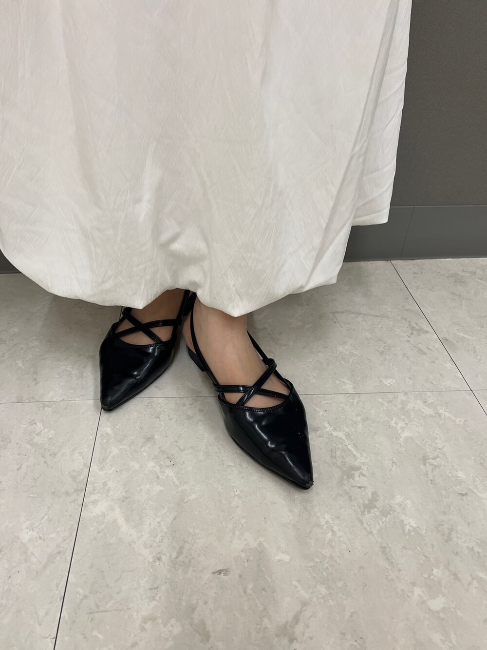 イエロー系のニット/セーター、ホワイト系のスカート、ブラック系のその他シューズを着用したレディースの秋コーディネートの4枚目の写真