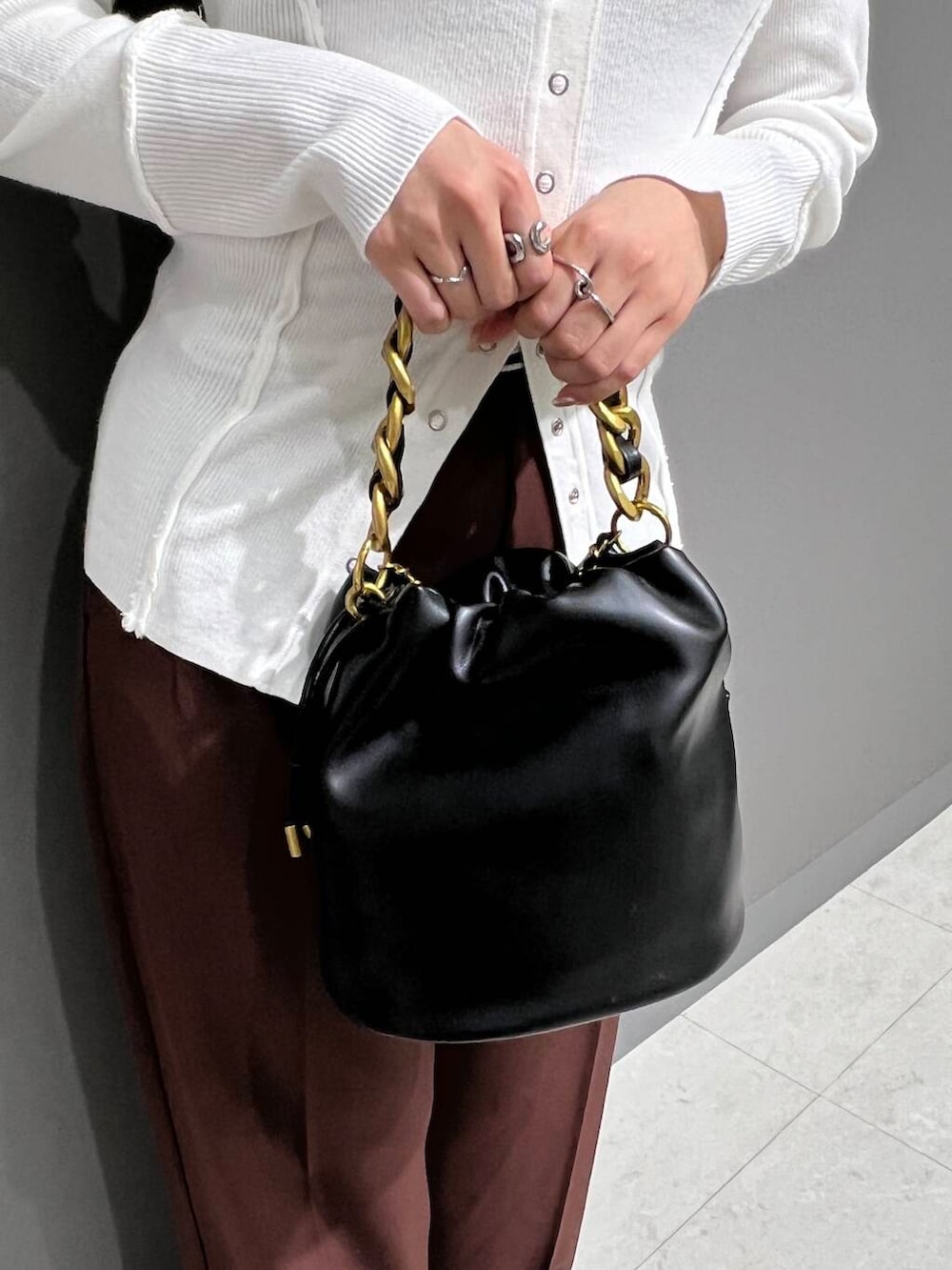 ブラック系のパンプス、ブラウン系のその他パンツ、ブラック系のショルダーバッグを着用したレディースの秋コーディネートの4枚目の写真