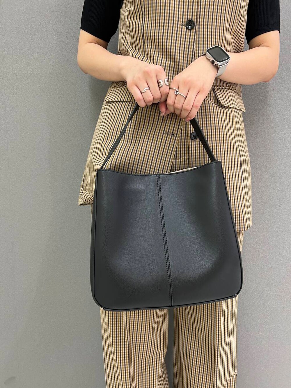 ブラック系のニット/セーター、ブラック系のハンドバッグ、ブラウン系のその他パンツを着用したレディースの夏コーディネートの5枚目の写真