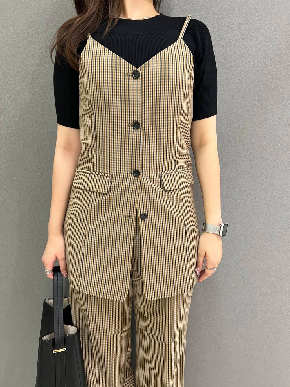 ブラック系のニット/セーター、ブラック系のハンドバッグ、ブラウン系のその他パンツを着用したレディースの夏コーディネートの2枚目の写真