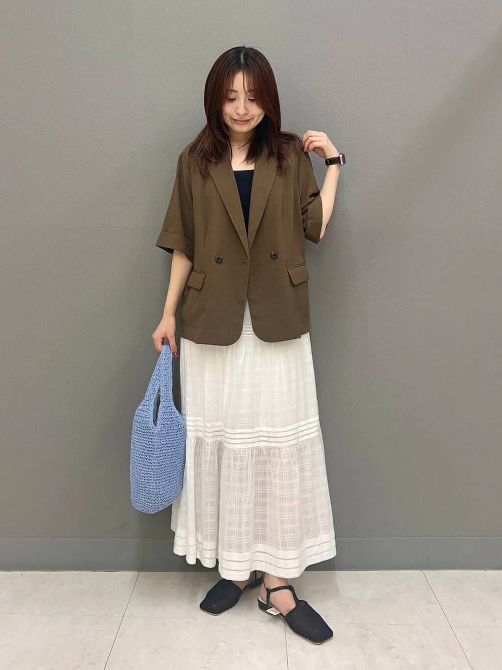 ブルー系のトートバッグ、ブラック系のパンプス、ブラウン系のその他アウターを着用したレディースの夏コーディネートの2枚目の写真