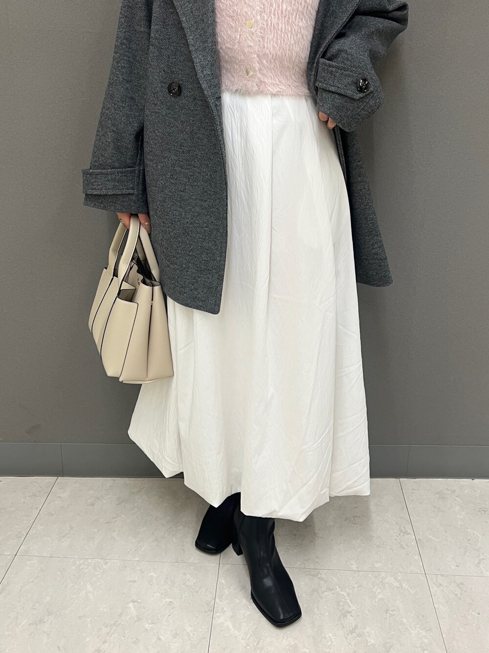 ピンク系のカーディガン/ボレロ、グレー系のその他アウター、ホワイト系のスカートを着用したレディースの秋コーディネートの3枚目の写真