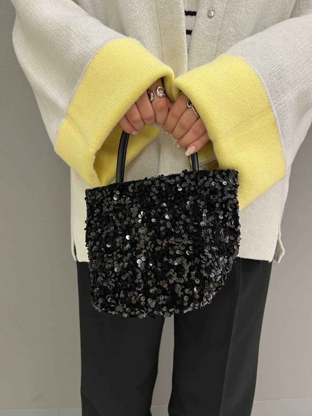 ホワイト系のニット/セーター、ブラック系のショルダーバッグ、ブラック系のその他パンツを着用したレディースの秋コーディネートの5枚目の写真