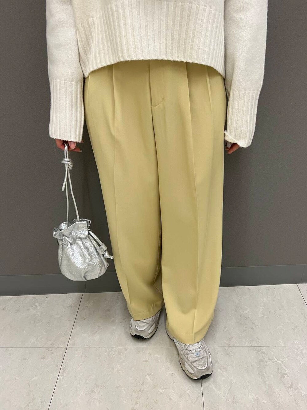 シルバー系のショルダーバッグ、イエロー系のその他パンツ、ホワイト系のニット/セーターを着用したレディースの冬コーディネートの3枚目の写真