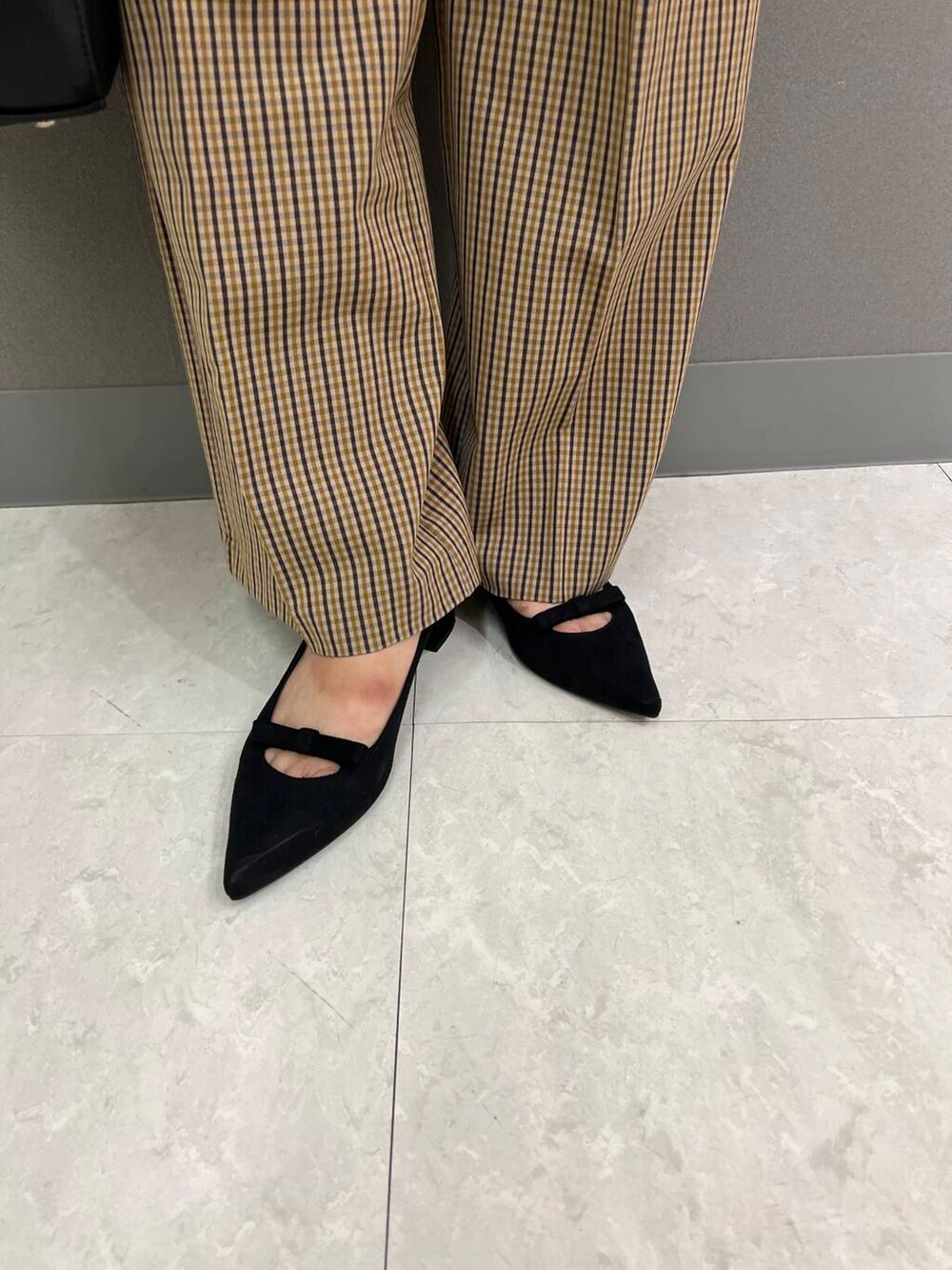 ブラック系のニット/セーター、ブラック系のハンドバッグ、ブラウン系のその他パンツを着用したレディースの夏コーディネートの4枚目の写真