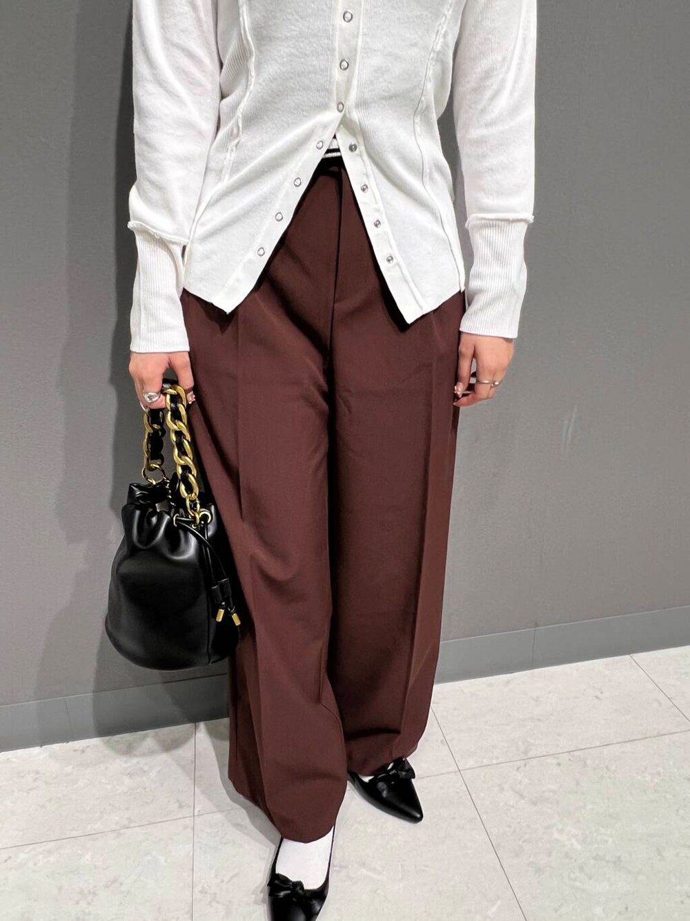 ブラック系のパンプス、ブラウン系のその他パンツ、ブラック系のショルダーバッグを着用したレディースの秋コーディネートの3枚目の写真