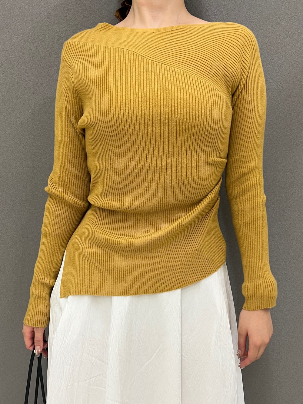 イエロー系のニット/セーター、ホワイト系のスカート、ブラック系のその他シューズを着用したレディースの秋コーディネートの2枚目の写真