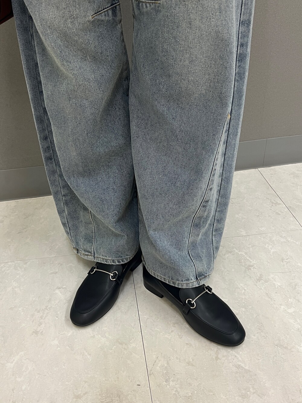 ベージュ系のブルゾン、ブラック系のニット/セーター、ブルー系のデニムパンツを着用したレディースの秋コーディネートの4枚目の写真