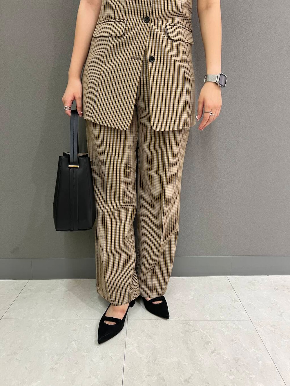 ブラック系のニット/セーター、ブラック系のハンドバッグ、ブラウン系のその他パンツを着用したレディースの夏コーディネートの3枚目の写真