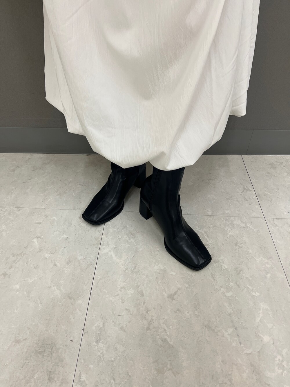 ピンク系のカーディガン/ボレロ、グレー系のその他アウター、ホワイト系のスカートを着用したレディースの秋コーディネートの4枚目の写真