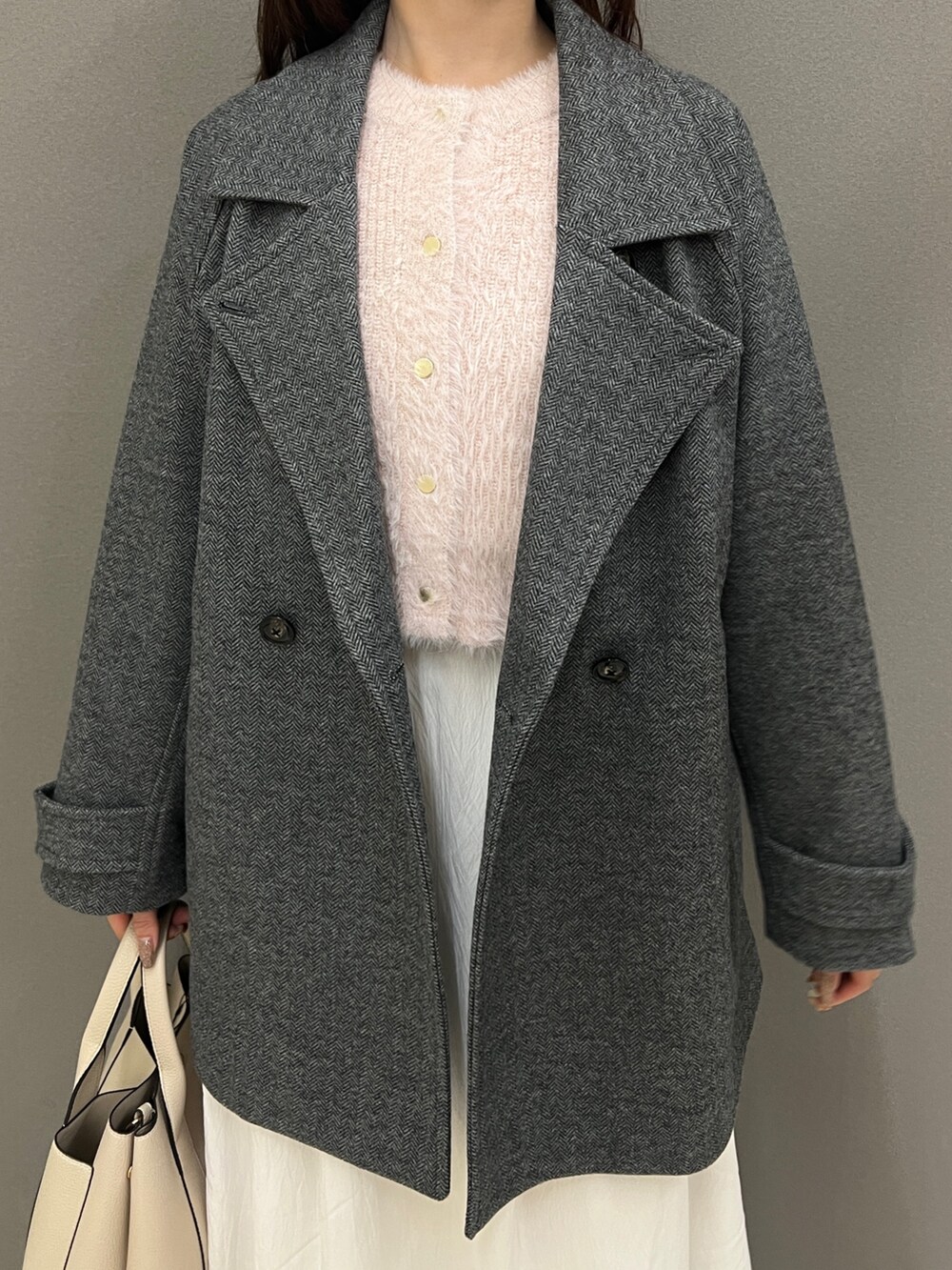 ピンク系のカーディガン/ボレロ、グレー系のその他アウター、ホワイト系のスカートを着用したレディースの秋コーディネートの2枚目の写真