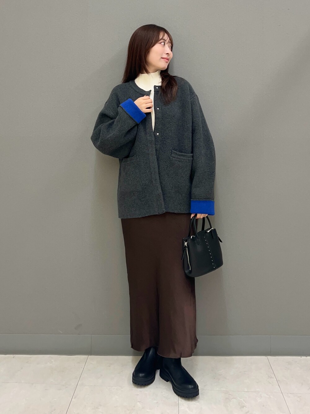 その他のその他アウター、ホワイト系のニット/セーター、ブラウン系のスカートを着用したレディースの秋コーディネートの2枚目の写真