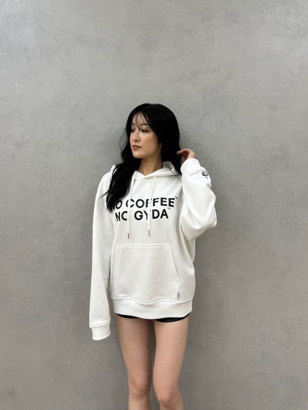 ホワイト系のパーカー、ブラック系のその他パンツ、ブラック系のブーツを着用したレディースの秋コーディネートの3枚目の写真