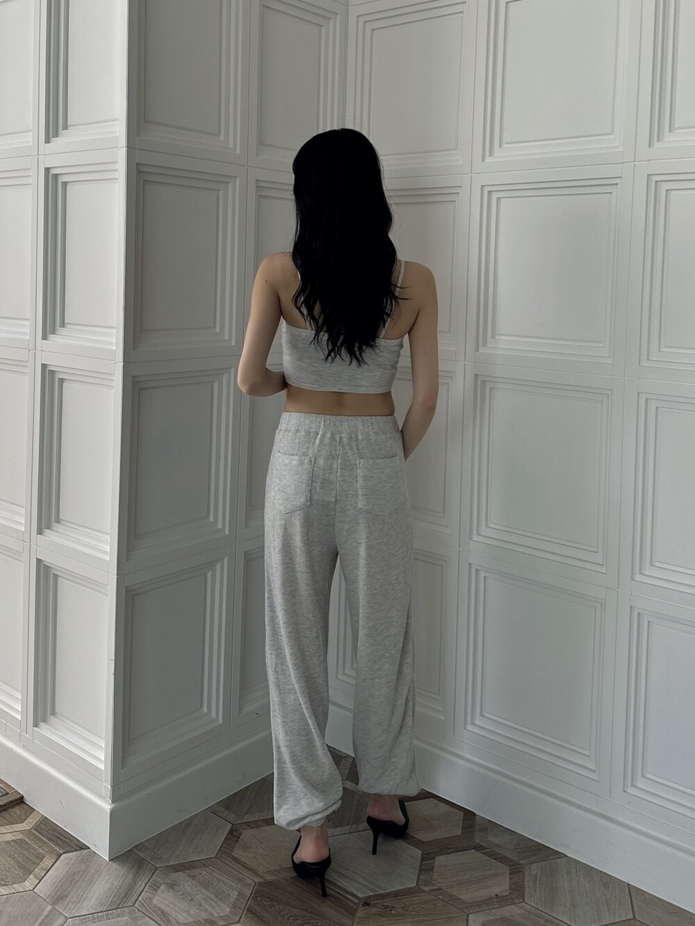 グレー系のキャミソール、グレー系のスウェットパンツ、ブラック系のパンプスを着用したレディースの夏コーディネートの2枚目の写真