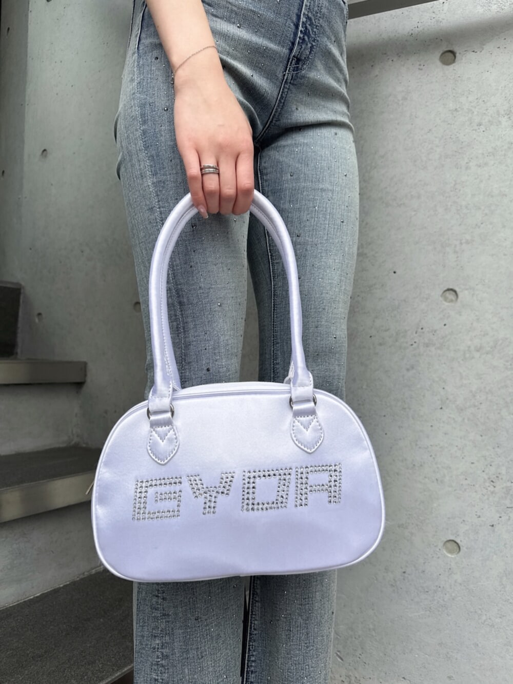 ホワイト系のニット/セーター、ブルー系のデニムパンツ、ホワイト系のボストンバッグを着用したレディースの夏コーディネートの9枚目の写真