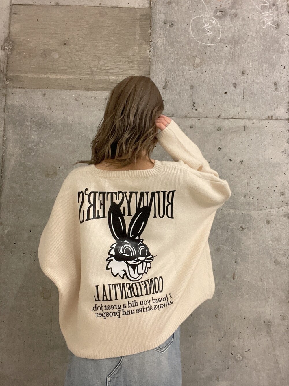 ホワイト系のニット/セーター、ブルー系のデニムスカート、ホワイト系のパンプスを着用したレディースの冬コーディネートの4枚目の写真