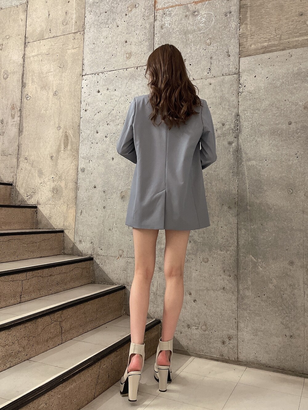 ブルー系のスカート、ブルー系のテーラードジャケット、ホワイト系のTシャツ/カットソーを着用したレディースの春コーディネートの3枚目の写真