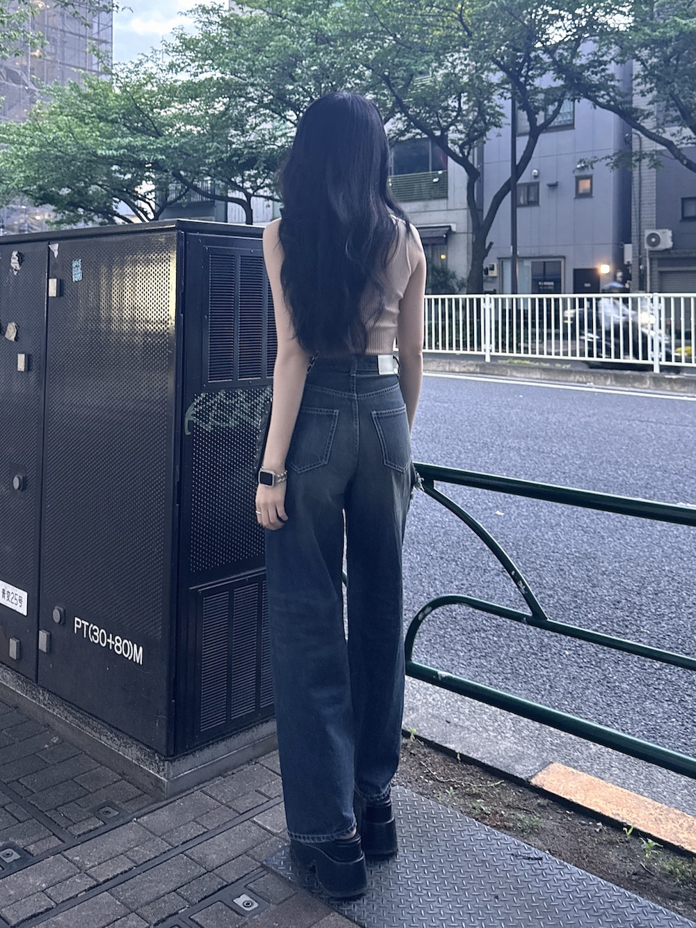 ベージュ系のキャミソール、ブルー系のデニムパンツ、ブラック系のショルダーバッグを着用したレディースの夏コーディネートの2枚目の写真