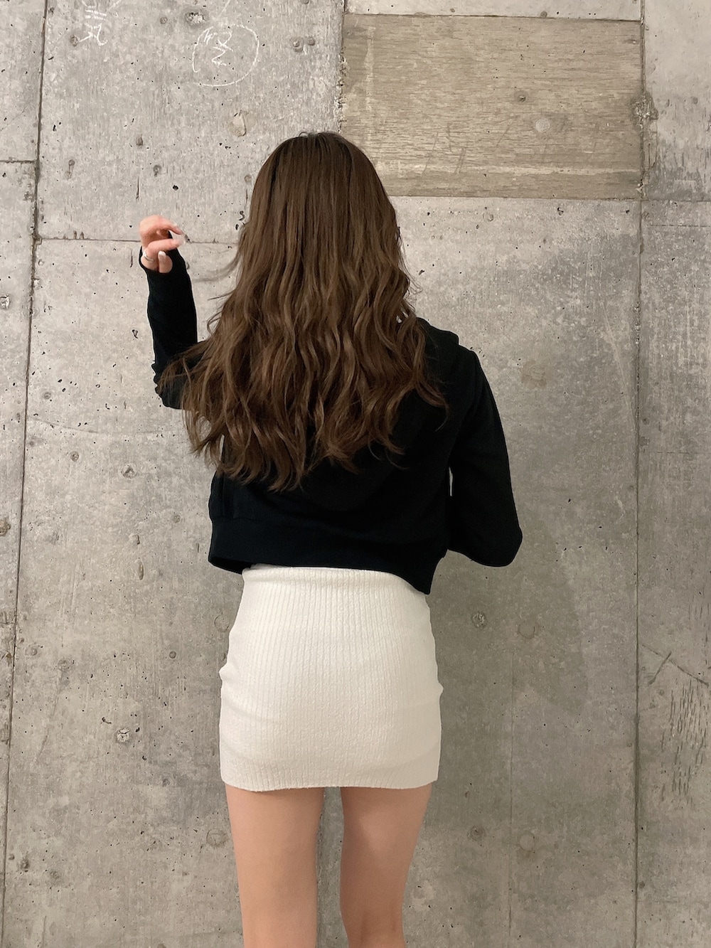 ブラック系のパーカー、ホワイト系のスカート、ホワイト系のキャミソールを着用したレディースの春コーディネートの4枚目の写真