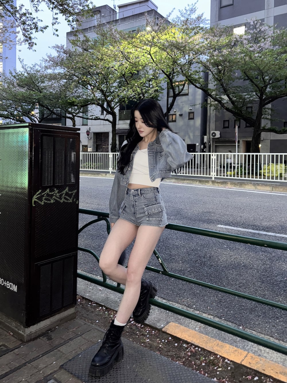 ブルー系のデニムジャケット、ブルー系のデニムパンツ、ブラック系のハンドバッグを着用したレディースの春コーディネートの4枚目の写真
