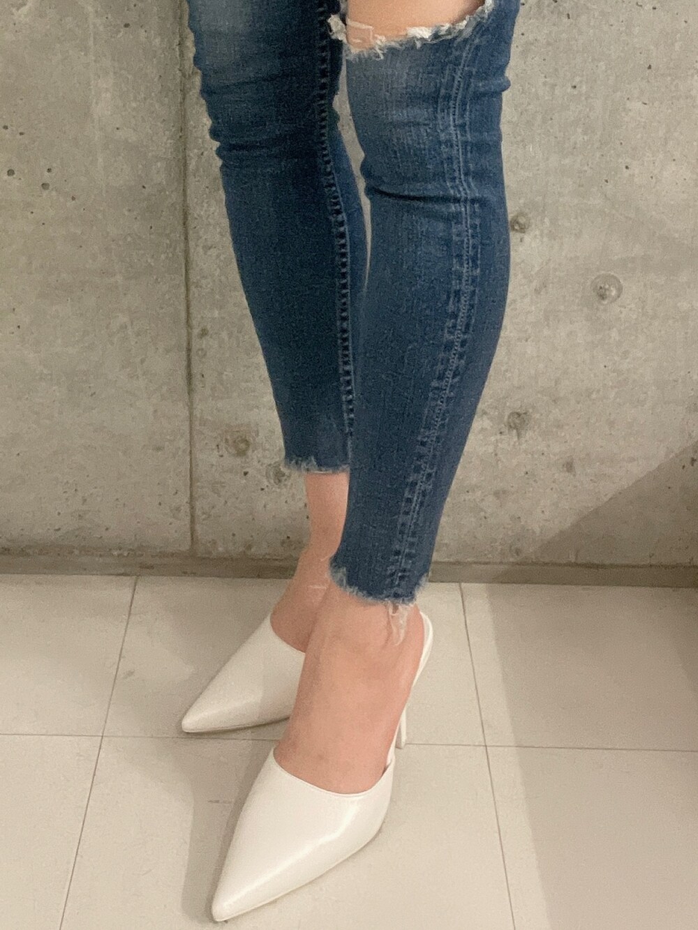 ブルー系のデニムパンツ、ホワイト系のシャツ/ブラウス、ホワイト系のパンプスを着用したレディースの冬コーディネートの9枚目の写真