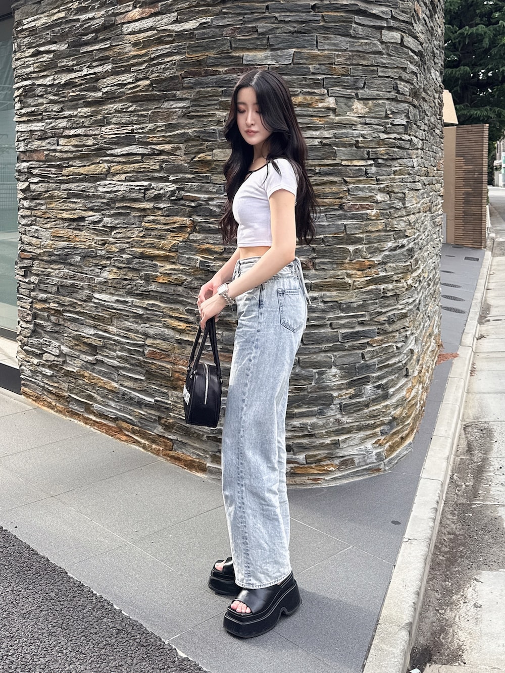 ホワイト系のTシャツ/カットソー、ブラック系のボストンバッグ、ブルー系のデニムパンツを着用したレディースの夏コーディネートの2枚目の写真