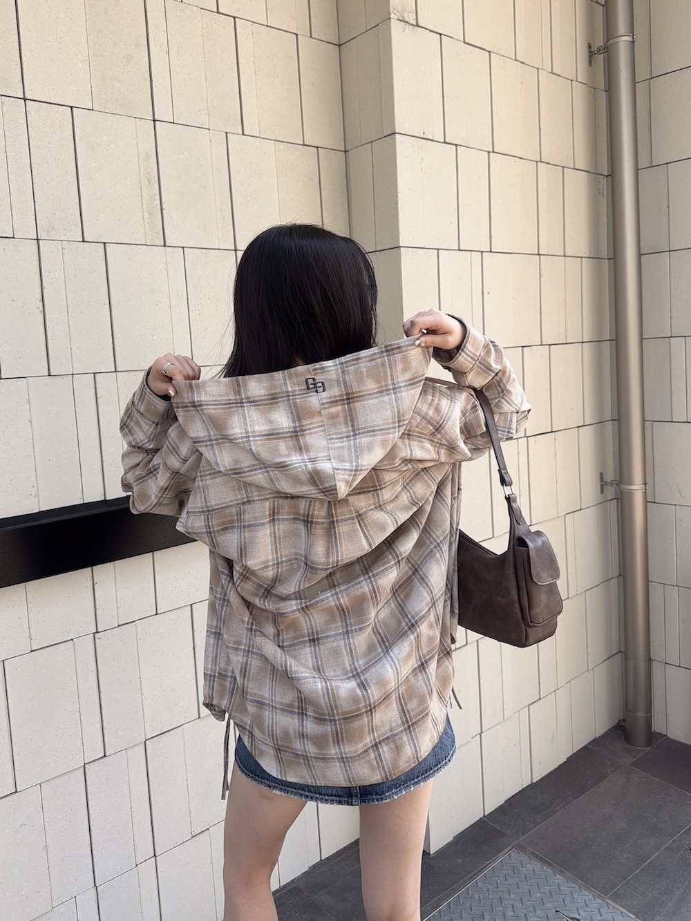 ブルー系のデニムスカート、ブラウン系のハンドバッグ、ベージュ系のシャツ/ブラウスを着用したレディースの夏コーディネートの5枚目の写真