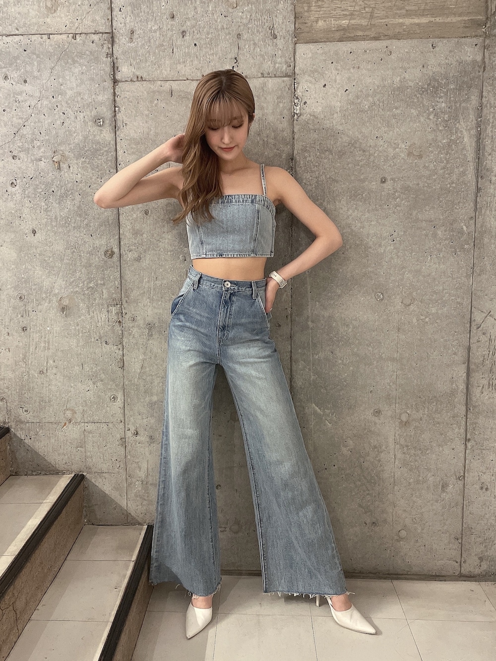 ブルー系のデニムパンツ、ホワイト系のパンプス、ブルー系のキャミソールを着用したレディースの夏コーディネートの4枚目の写真