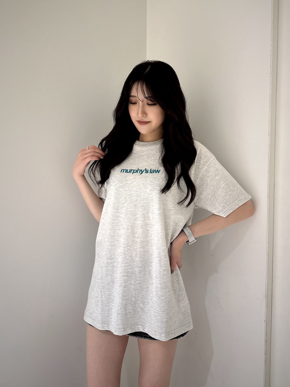 グレー系のTシャツ/カットソー、ブラック系のデニムスカート、ブラック系のサンダルを着用したレディースの夏コーディネートの3枚目の写真