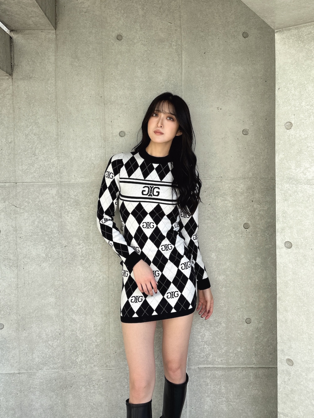 ブラック系のワンピース、ブラック系のブーツを着用したレディースの冬コーディネートの3枚目の写真