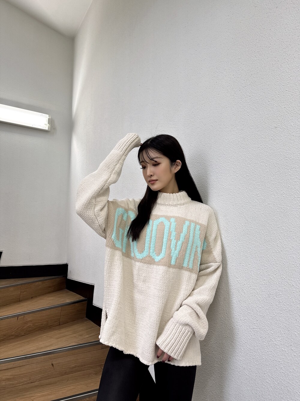 ホワイト系のニット/セーター、ホワイト系のパンプス、ブラック系のレギンス/スパッツを着用したレディースの秋コーディネートの2枚目の写真