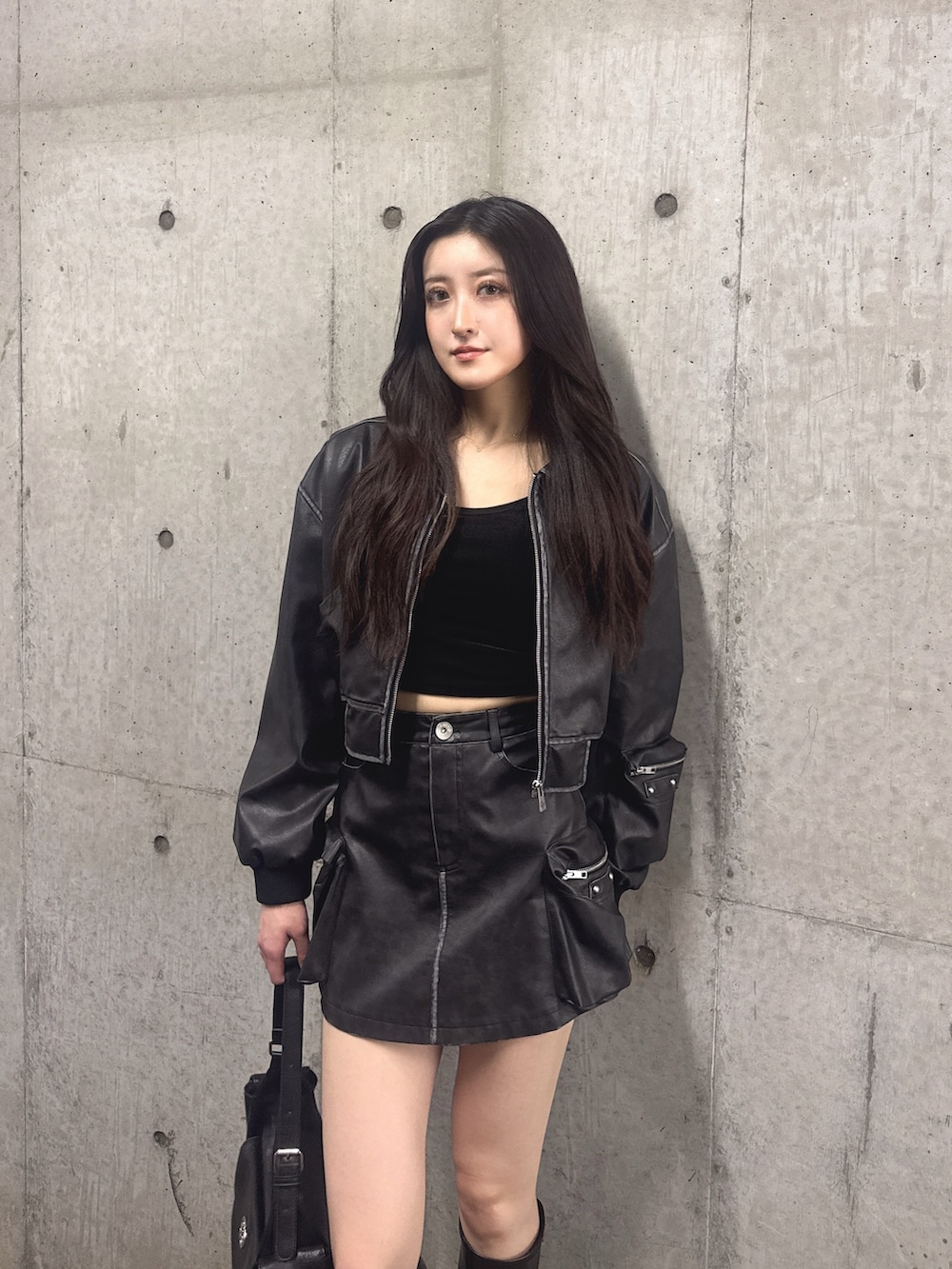 ブラック系のスカート、ブラック系のブーツ、ブラック系のブルゾンを着用したレディースの秋コーディネートの3枚目の写真