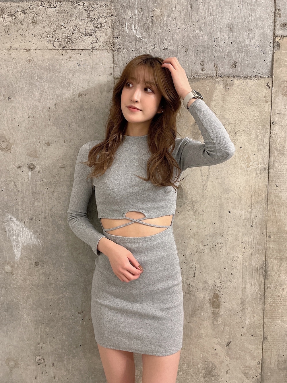 グレー系のワンピース、ブラック系のブーツを着用したレディースの冬コーディネートの2枚目の写真