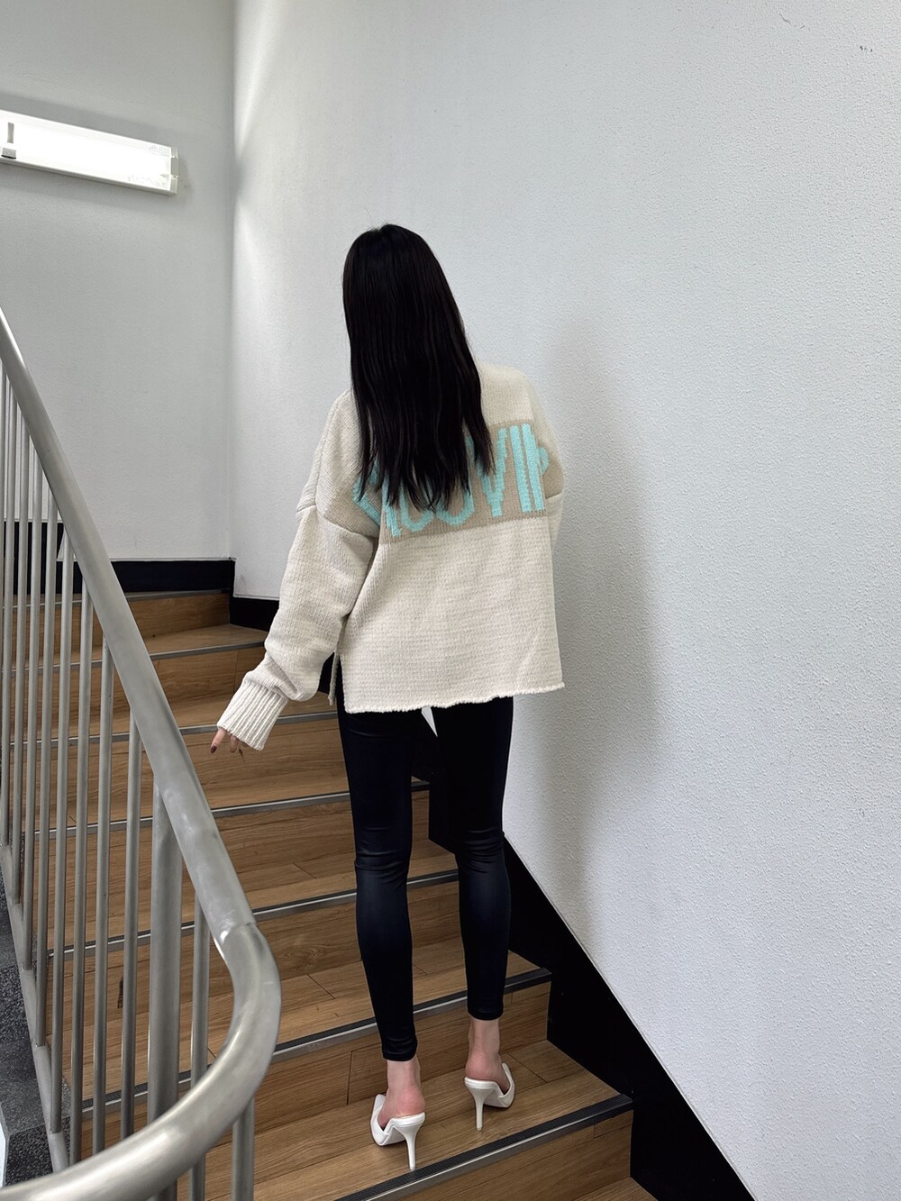 ホワイト系のニット/セーター、ホワイト系のパンプス、ブラック系のレギンス/スパッツを着用したレディースの秋コーディネートの3枚目の写真