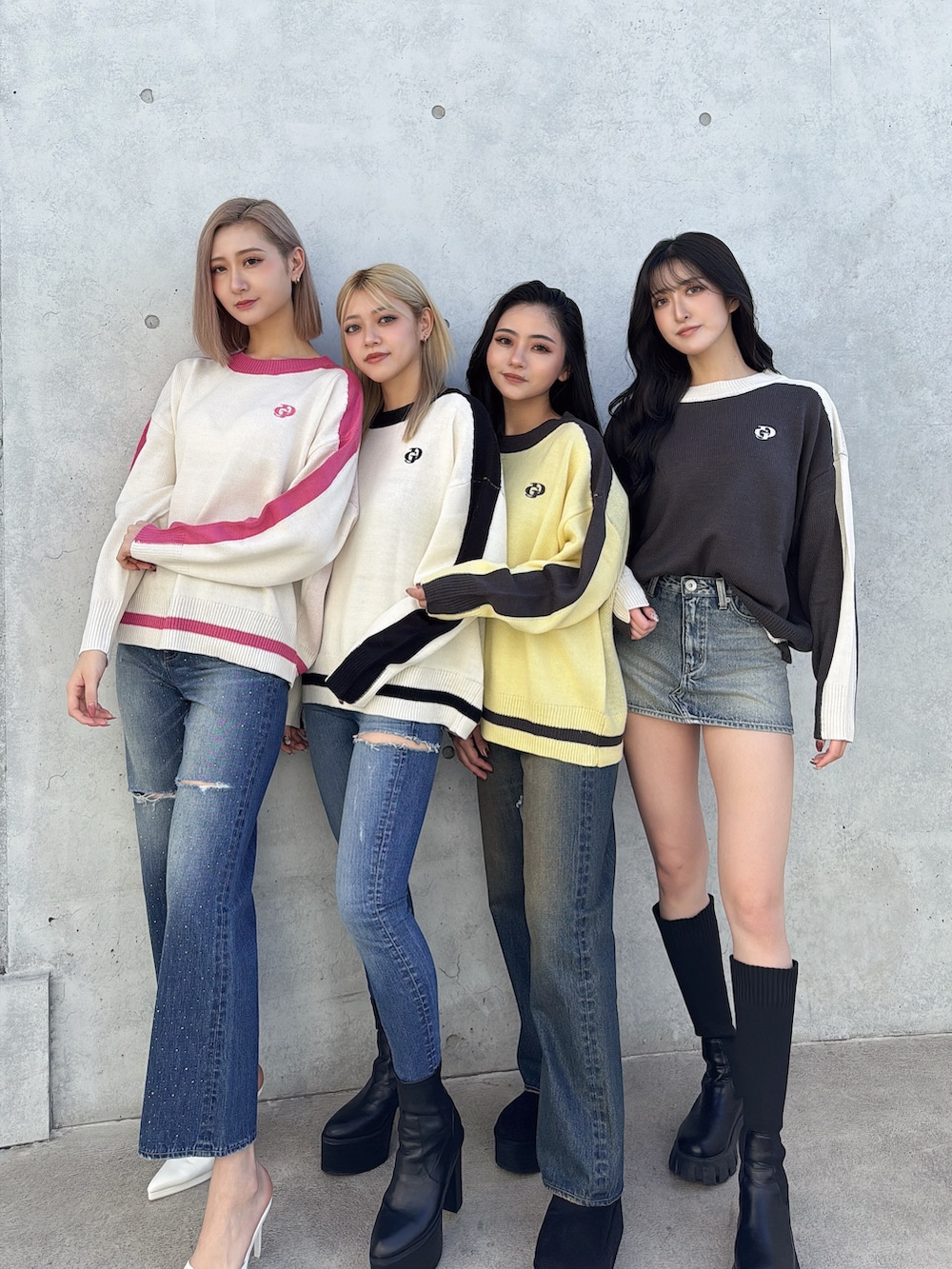 グレー系のニット/セーター、ブルー系のデニムスカート、ブラック系のブーツを着用したレディースの冬コーディネートの2枚目の写真