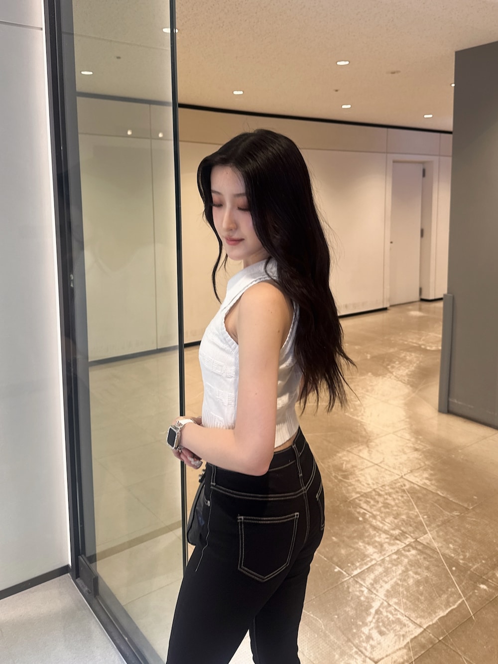 ホワイト系のニット/セーター、ブラック系のデニムパンツ、その他のサンダルを着用したレディースの夏コーディネートの4枚目の写真