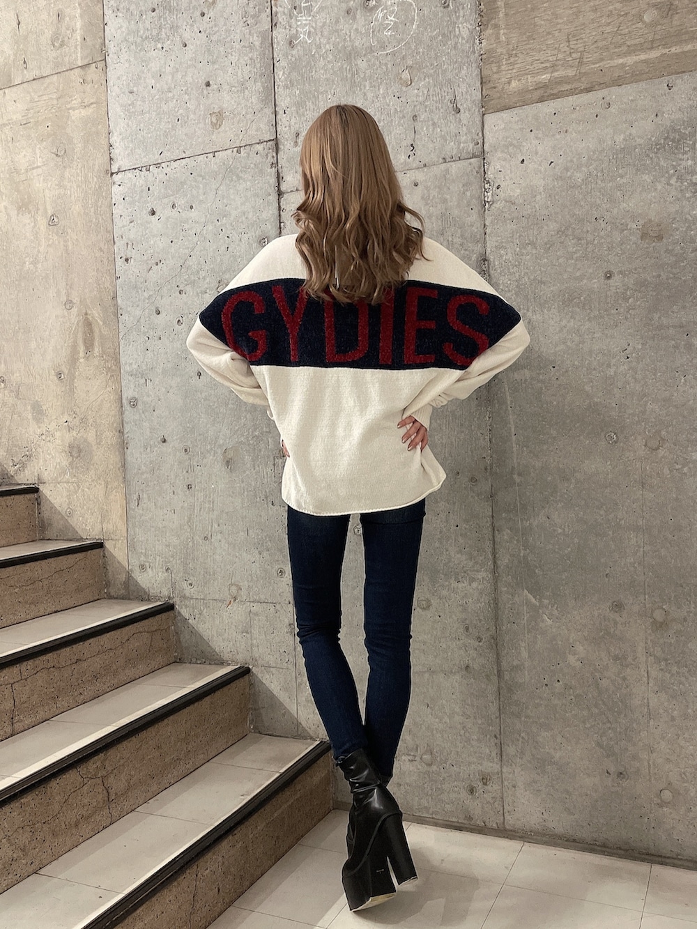 ホワイト系のニット/セーター、ブルー系のデニムパンツ、ブラック系のブーツを着用したレディースの秋コーディネートの3枚目の写真