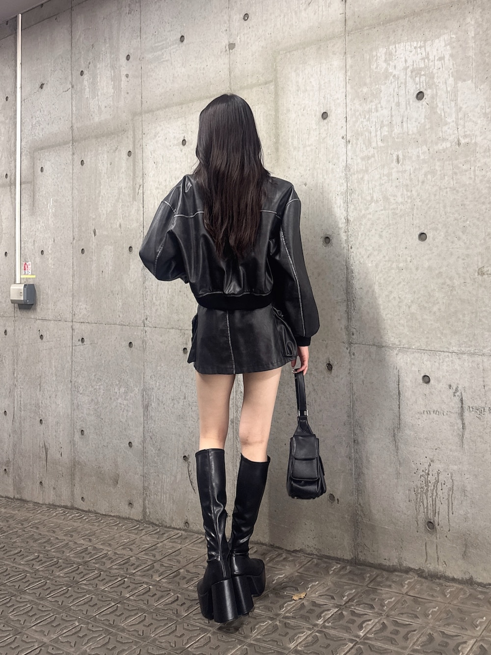 ブラック系のスカート、ブラック系のブーツ、ブラック系のブルゾンを着用したレディースの秋コーディネートの2枚目の写真