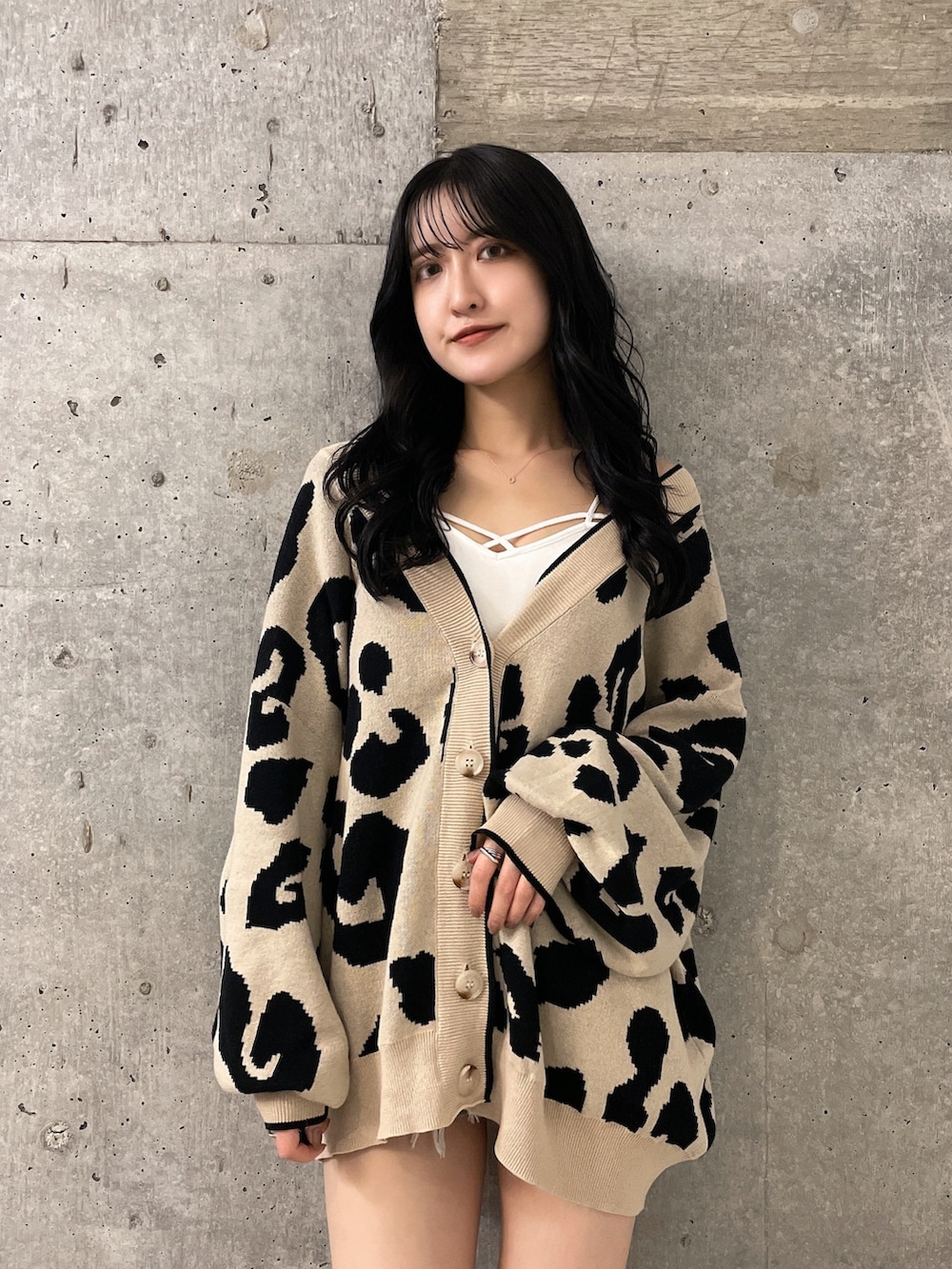 ブルー系のデニムパンツ、ホワイト系のキャミソール、ベージュ系のカーディガン/ボレロを着用したレディースの夏コーディネートの3枚目の写真