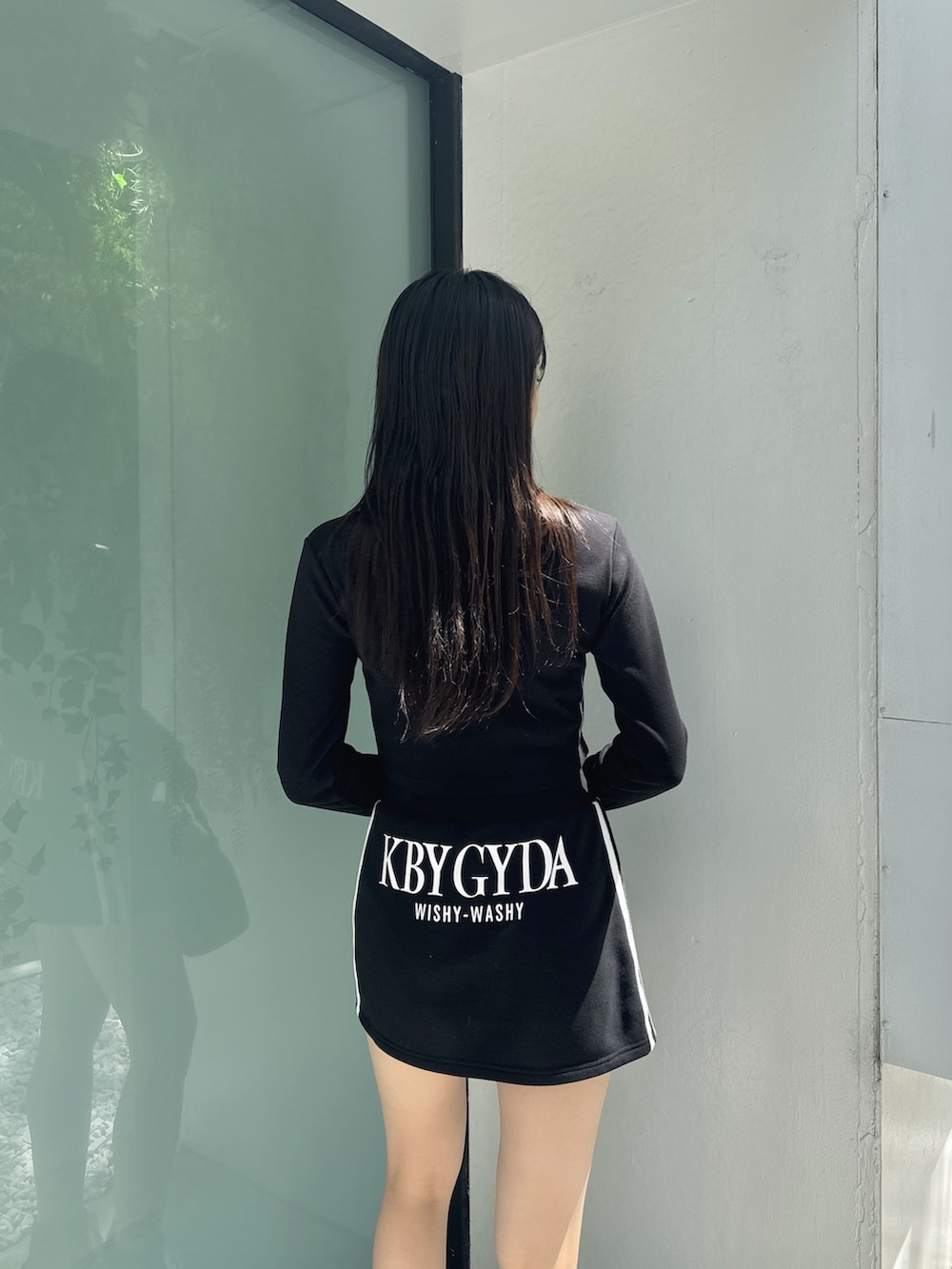 ブラック系のTシャツ/カットソー、ブラック系のスカート、ブラック系のブーツを着用したレディースの秋コーディネートの3枚目の写真