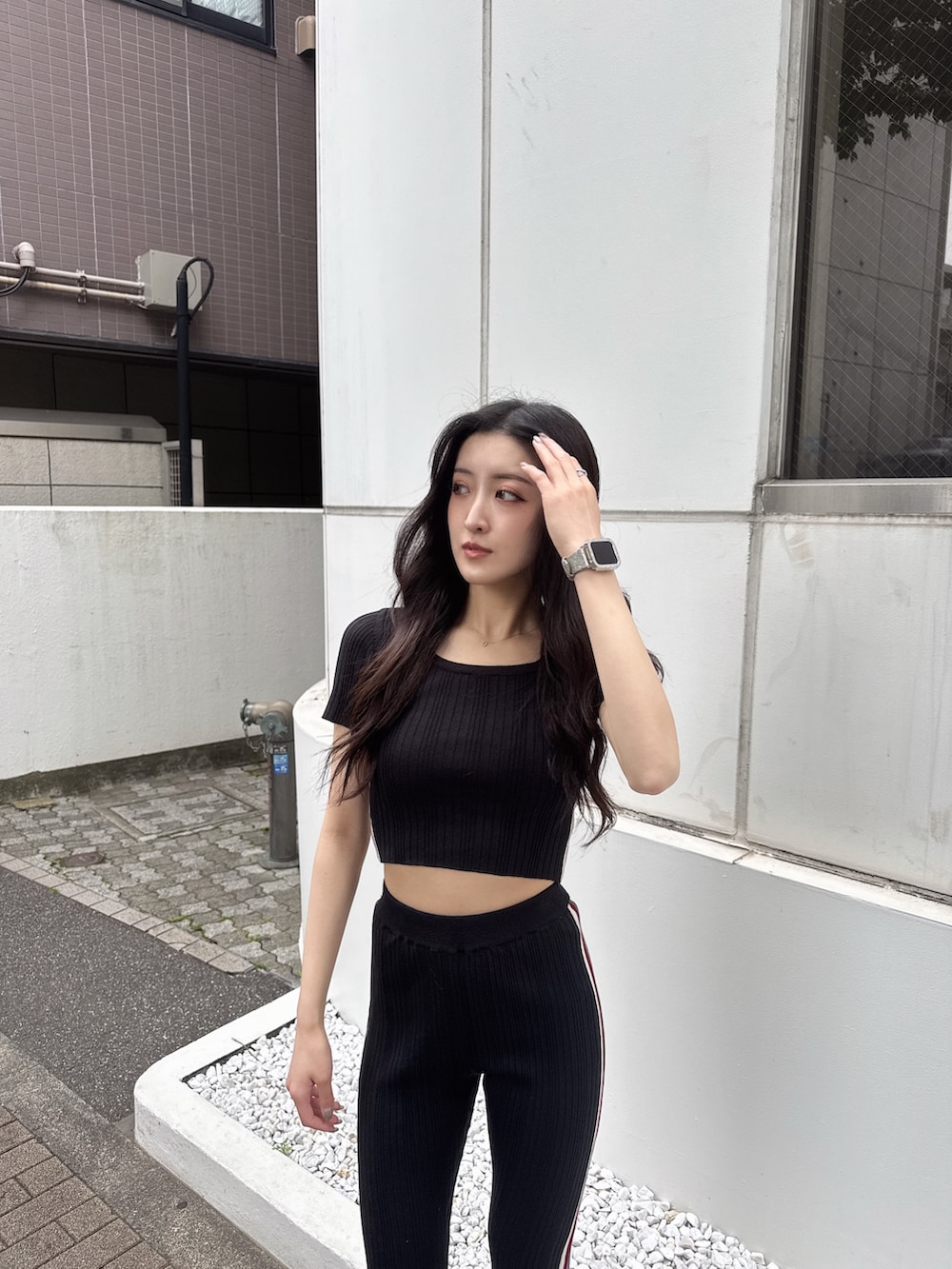 ブラック系のその他パンツ、ブラック系のニット/セーター、ブラック系のパンプスを着用したレディースの春コーディネートの2枚目の写真