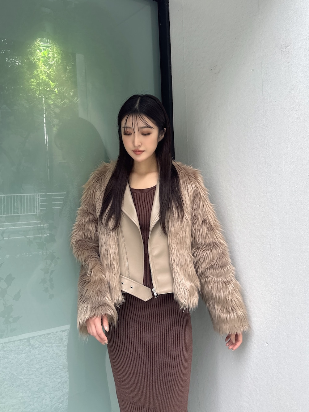 ベージュ系のライダースジャケット、ブラウン系のワンピース、ブラック系のパンプスを着用したレディースの秋コーディネートの3枚目の写真